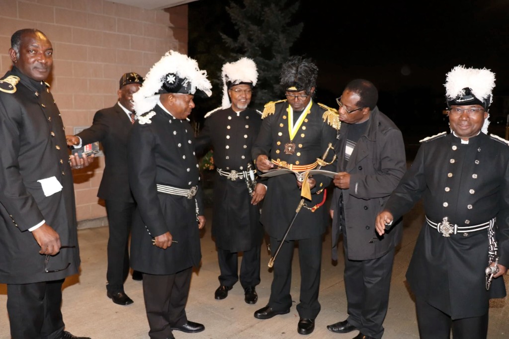 Knights in ceremonial uniform gathered at night—brothers in shared counsel and fraternity