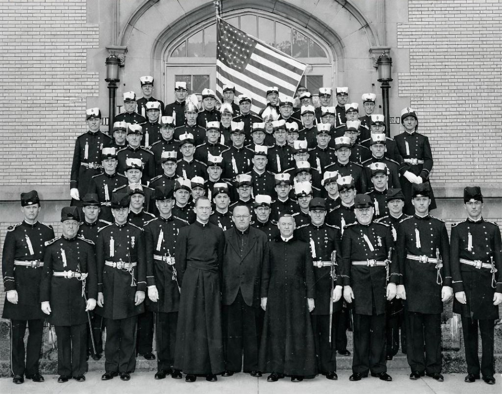 Historical formal photograph — Knights of St. John in ceremonial uniform with clergy and United States flag